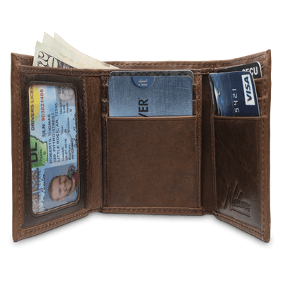 A classic for anyone's collection, the Dynasty Trifold Shotshell Wallet comes with a beautiful hand-oiled finish within a premier full grain leather. The signature shotshell concho makes it the perfect piece for any outdoor enthusiast. Don't miss out! 6 Card Slots 2 Storage Pockets 1 ID Window Leather Tipped Bill Compartment Dimensions: 3.37"L x 4"H RFID Protection Color: Brown