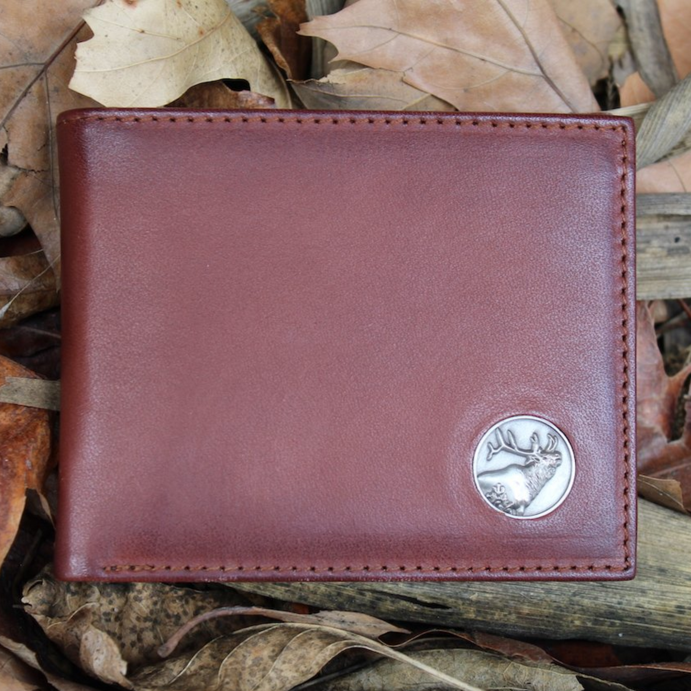 The Wildlife Bifold Elk Wallet is created from hand-burnished, rich full grain leather, providing a beautiful aged patina. The elk concho provides a personalized touch...stylish and unique, this piece is a must-have for any collection! 8 Card Slots 3 Storage Pockets 2 ID Windows Leather Tipped Bill Divider Weber's Signature Elk Concho Dimensions: 4.5"L x 3.5"H RFID Protection Color: Caramel