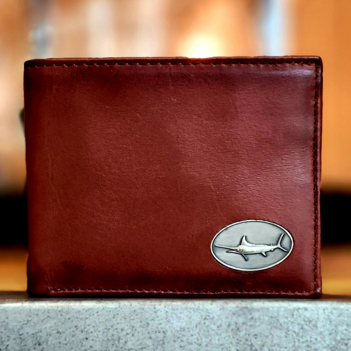 The Wildlife Bifold Marlin Wallet speaks volumes with its hand-burnished finish, signature marlin concho, and rich full grain leather. You won't be disappointed with this piece. 8 Card Slots 3 Storage Pockets 2 ID Windows Leather Tipped Bill Compartment Dimensions: 4.5"L x 3.5"H RFID Protection Color: Caramel